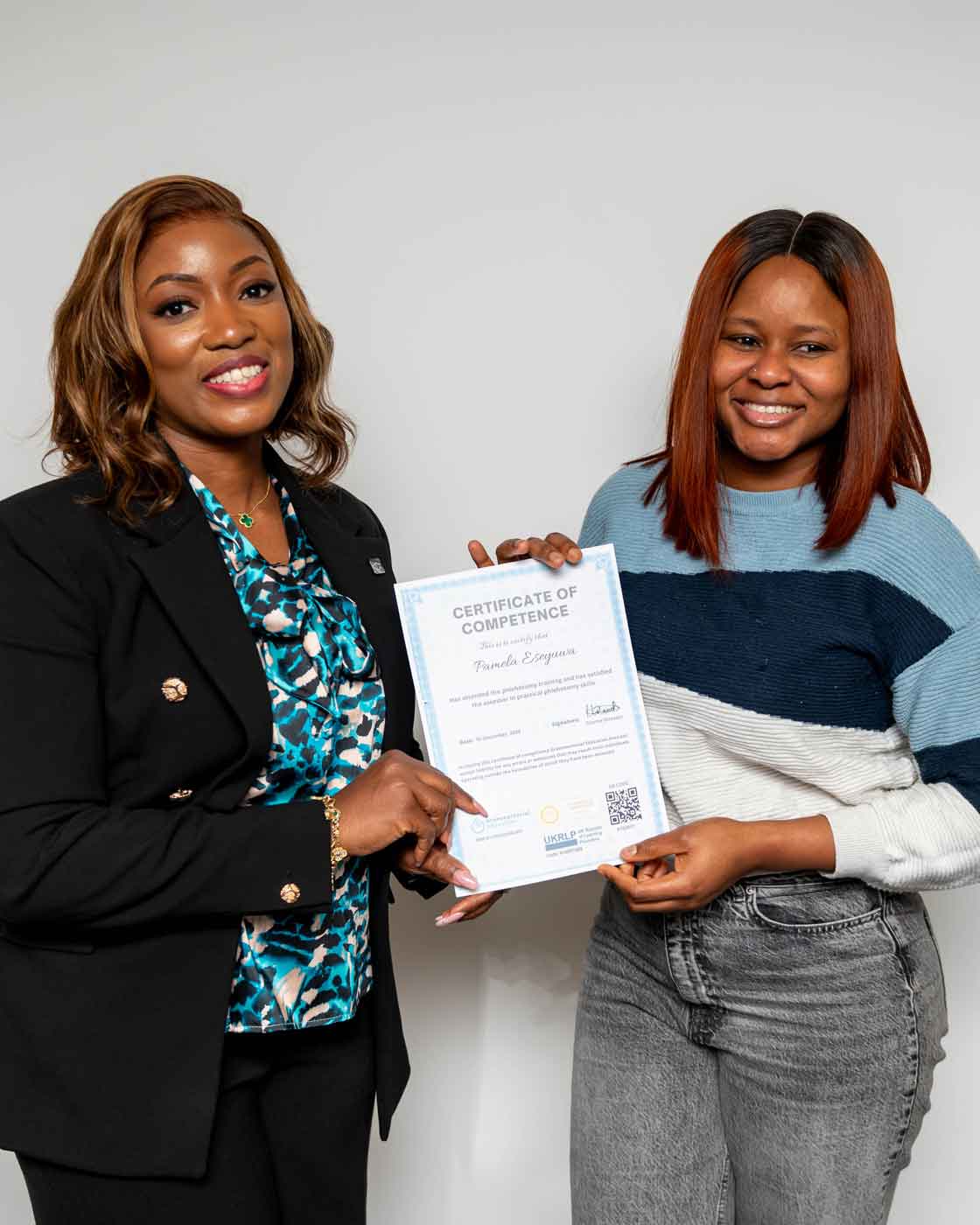 Luara handing phlebotomy student a certificate